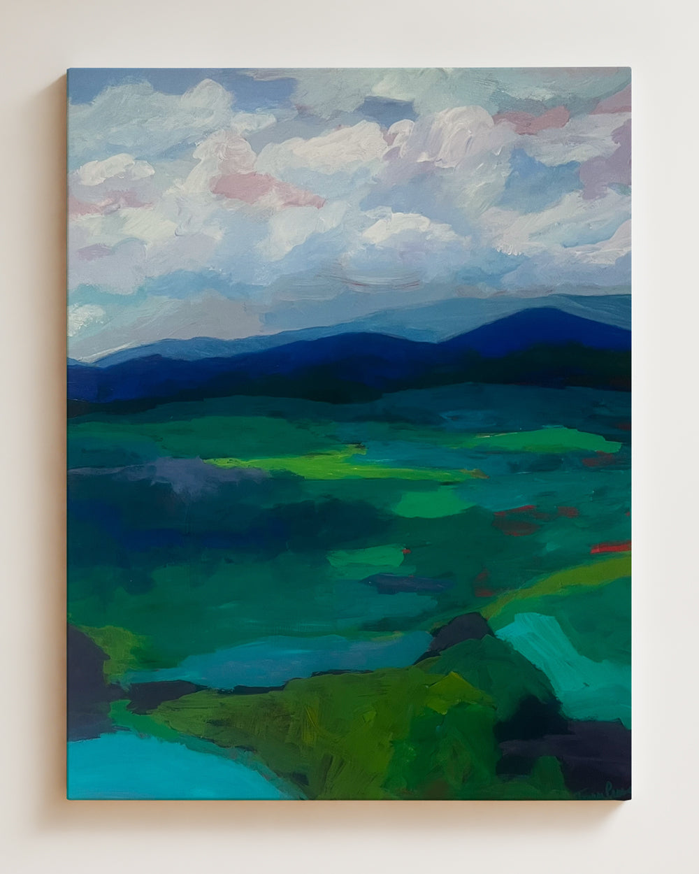 Painting of a landscape on cradled wooden panel with green fields and blue mountains on a white wall. Full view. Shop original landscape artwork and contemporary painting by Terry Pesso that blends abstraction, memory, and natural rhythm. These expressive works use layered color and motion to create dramatic wall art decor and are ideal for framed art and framed wall art presentation.