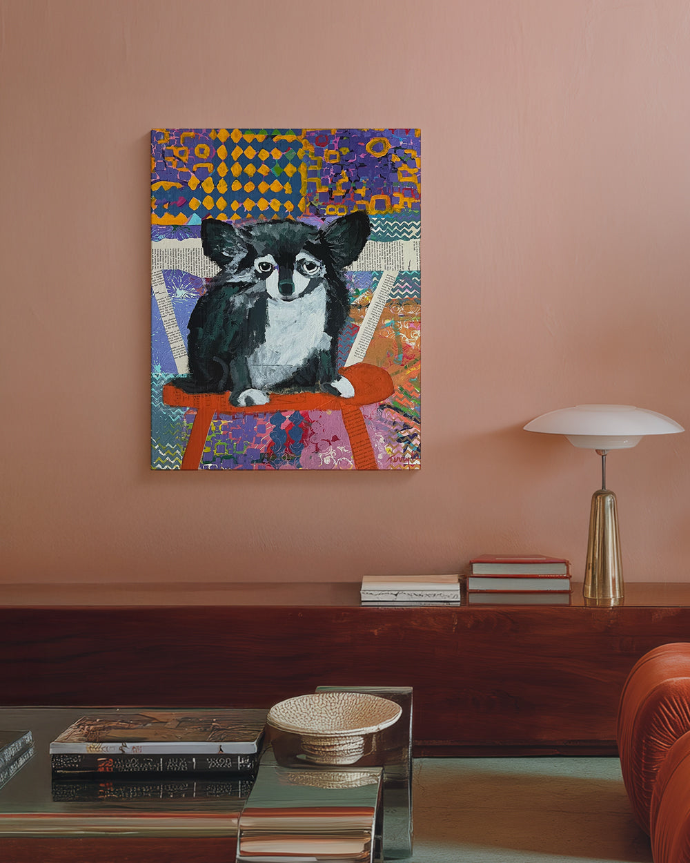 Colorful abstract painting of a dog on a wall above a wooden console table. Lifestyle mockup shot. "Devoted" is an original mixed media painting that captures the soulful presence of a dog against a richly textured, patterned background. Layers of color, collage, and brushwork combine to create depth and emotion, blending realism with abstract design. The expressive eyes and thoughtful pose bring warmth and personality to the piece, making it a perfect addition for dog lovers and collectors of contemporary 