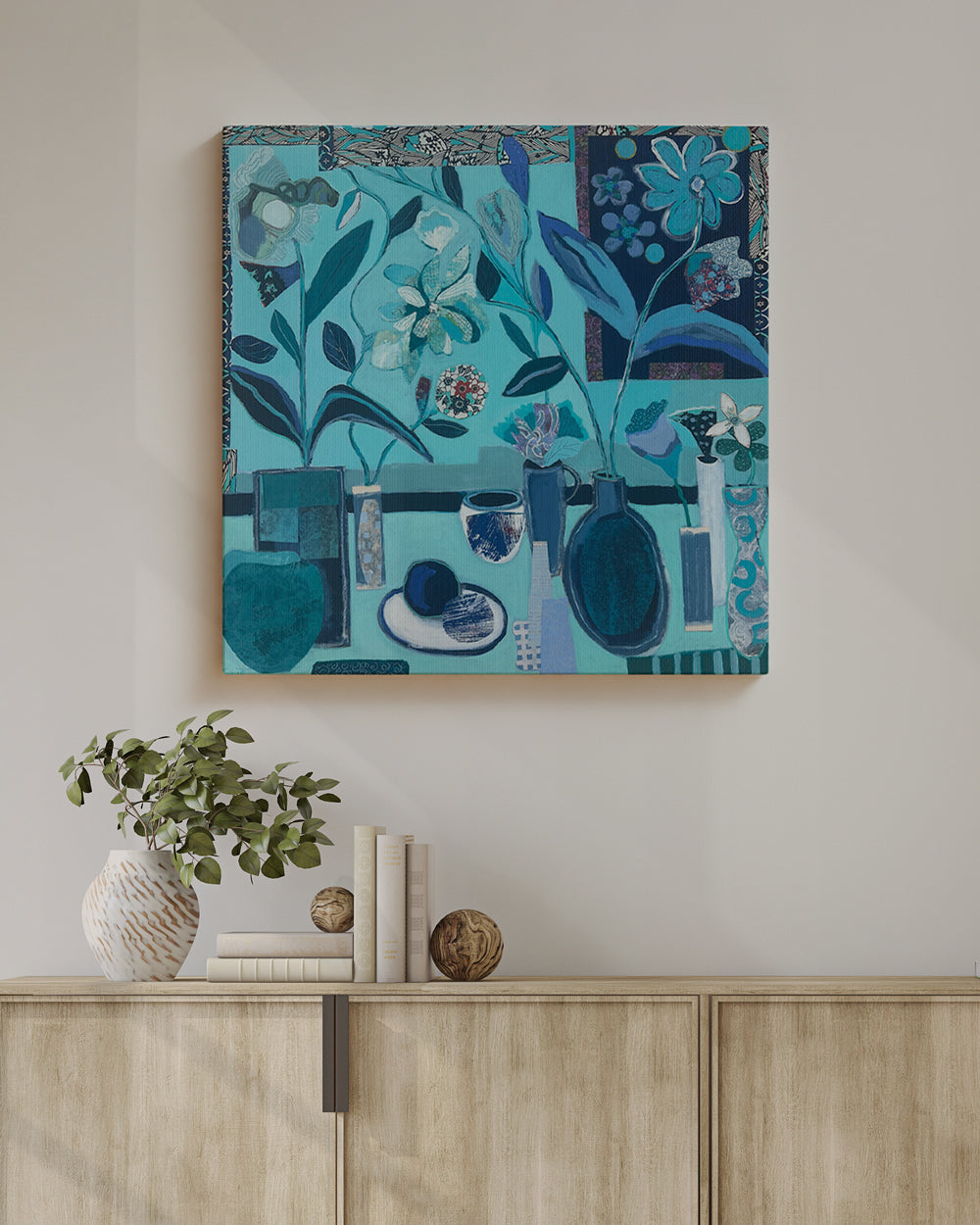 Abstract blue artwork on a wall above a wooden cabinet with decorative items. Lifestyle mockup of canvas. An original still life artwork and contemporary painting by Terry Pesso inspired by everyday objects, vessels, and quiet moments. These expressive works elevate ordinary subjects into refined wall art decor and are suitable for framed art and framed wall art.