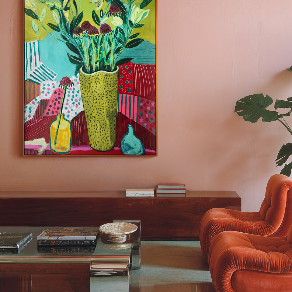 Colorful painting of a vase with plants on a wall above a coffee table with books and a bowl. Color-driven original artwork and contemporary painting by Terry Pesso created in acrylic and mixed media. Ready for framed art and framed wall art as vibrant wall art decor for modern interiors.