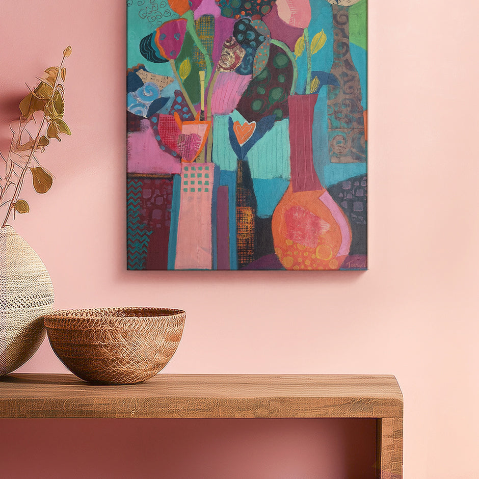 Colorful abstract painting on a pink wall above a wooden shelf with decorative items. Original floral artwork and contemporary painting by Terry Pesso featuring expressive color and layered design. Created for wall art decor and suitable for framed art and framed wall art.