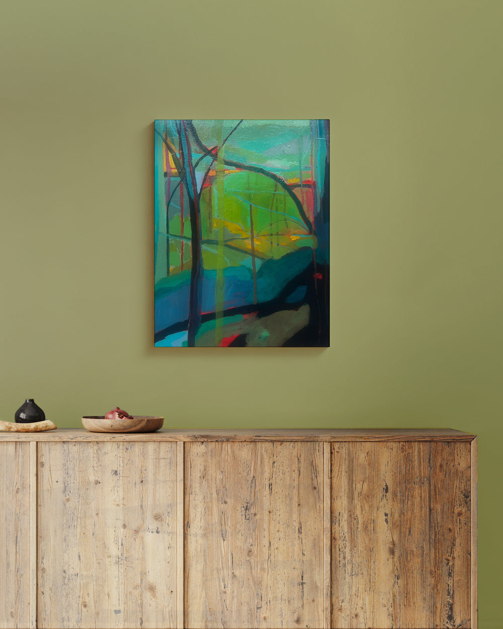 Abstract painting on a green wall above a wooden cabinet on cradle wood panel. Lifestyle mockup. Shop original landscape artwork and contemporary painting by Terry Pesso that blends abstraction, memory, and natural rhythm. These expressive works use layered color and motion to create dramatic wall art decor and are ideal for framed art and framed wall art presentation.