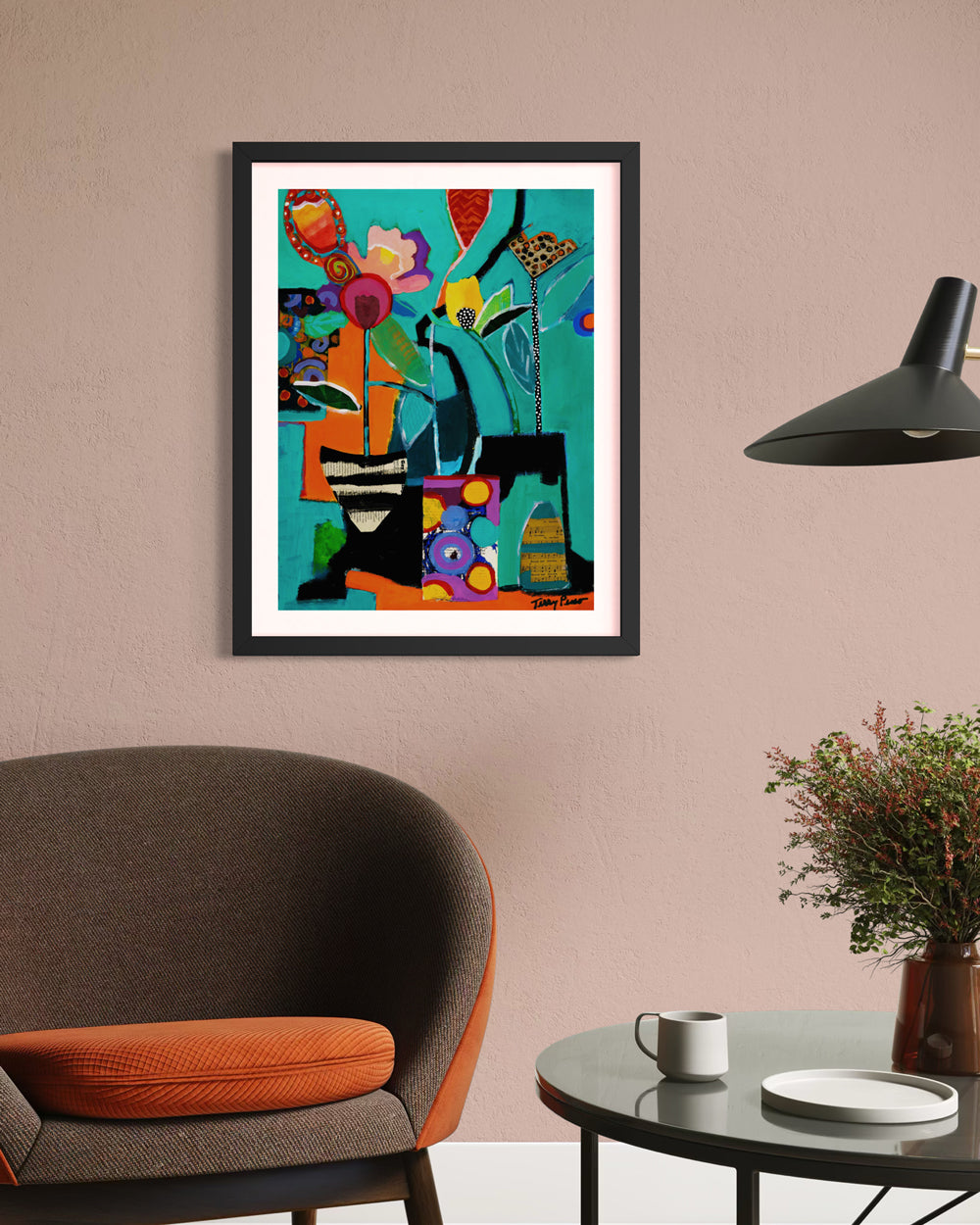 Framed colorful abstract painting on a wall above a chair with a table and lamp. Lifestyle mockup view. Shop original floral and botanical artwork and contemporary painting by Terry Pesso inspired by blooms, leaves, and organic form. These vibrant mixed media paintings bring fresh energy to wall art decor and are ready for framed art and framed wall art display.